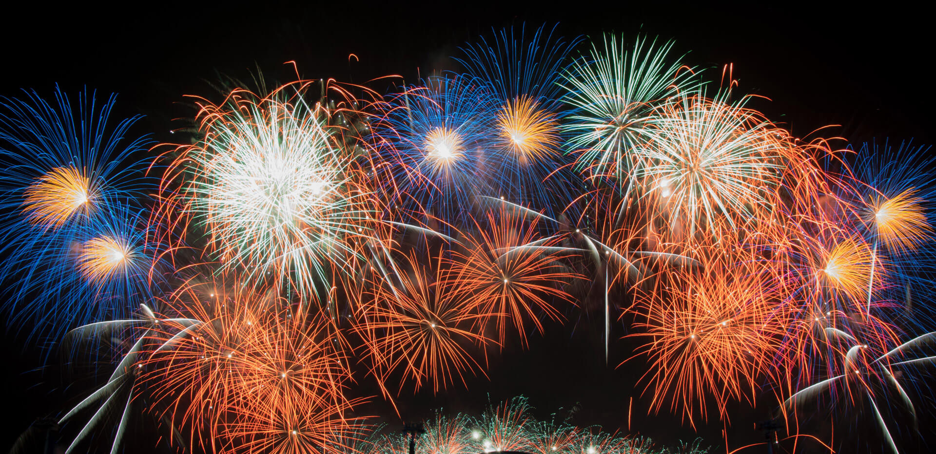 firework display in reds, white, blue, green and orange